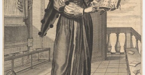 Grammar: a young woman standing in a decorated interior holding an open book in her left hand and pointing to the alphabet inscribed on its pages with her right hand.
