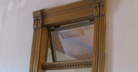 An open transom window above an old wooden door frame.